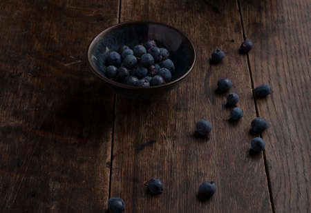 Bowl of blueberries on the old wooden tableの写真素材