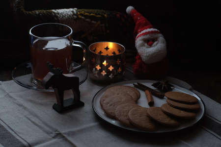 Christmas breakfast. Tea and gingerbread cookies plate, candle and soft toy Santaの写真素材