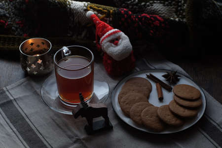 Christmas breakfast. Tea and gingerbread cookies plate, candle and soft toy Santaの写真素材