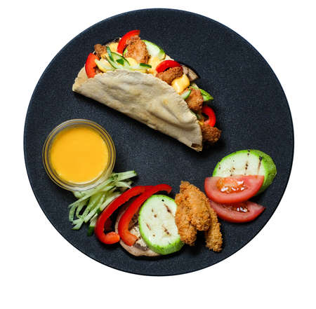 Top view Hot taco with ingridients and salsa on the black plate isolatedの写真素材