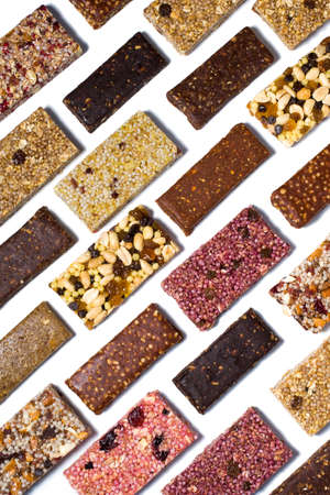 Flat lay composition with cereal granola and protein bars with nuts and dry fruit berries on the white backroundの写真素材