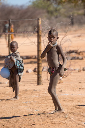 Himba village, Namibia, Africa, June 18, 2019: Two Himba children stand in the middle of the village...