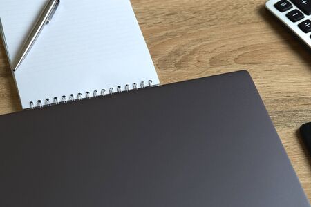 Remote work laptop calculator notepad with pen on the table