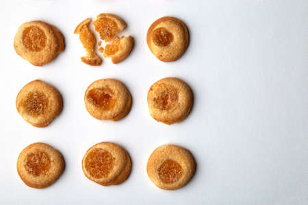 Nine handmade cookies with apricot jam arranged in even rows with free space for text. One in the...