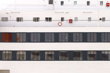 Ready for travel. Woman ferry worker standing near one of boat window. Oudoor view from sideways.の写真素材