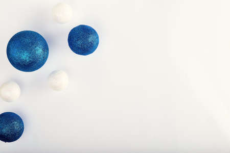 Horizontal shot of three blue balls and three decorative snowballs at left. With gold presents at right. on white background. Top view with copy space for textの写真素材