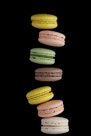 Macaroon. Colorful cake macaron with pastel tones fall at the stack macaroon on black background. Top view of almond cookiesの写真素材