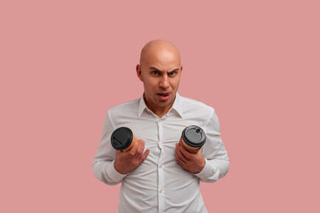 Funny bald man with bristle, fooling, makes tits with two disposable paper cups,, shows tongue,...