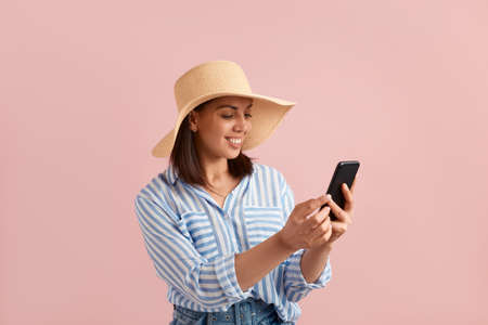 Happy smiling woman is looking at mobile phone, received good news, chatting with her friend, found...
