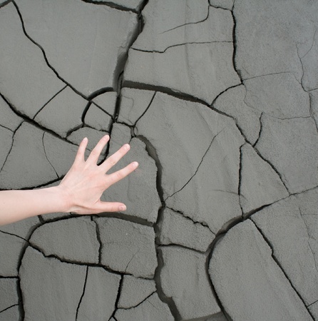 Photo of a hand over cracked landの写真素材