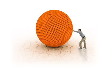 Young man pushing big and heavy ball on cracked earthの写真素材