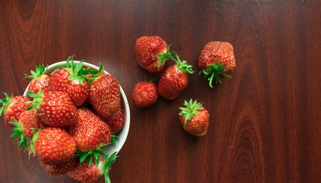 Fresh red strawberry close-up on a dark-brown wooden backgroundの写真素材