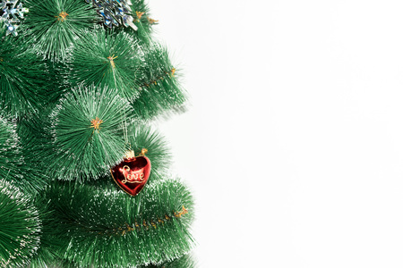 On a white background Christmas-tree branch and displayed on it hanging red with gold rerelivom toy and love inscriptionの写真素材