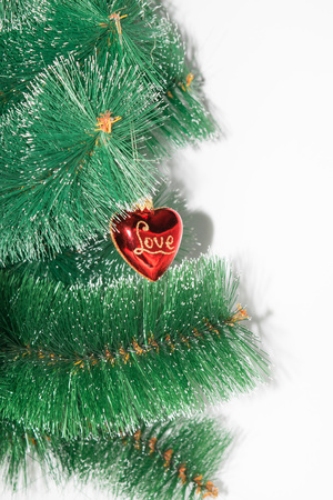 On a white background Christmas-tree branch and displayed on it hanging red with gold rerelivom toy and love inscriptionの写真素材