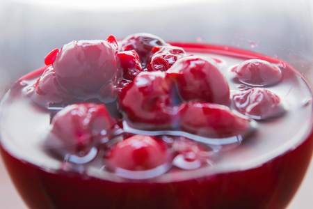 Cherry jam closeup of a wine glass on a light backgroundの写真素材
