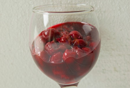 Cherry jam close up of a wine glass on a light backgroundの写真素材