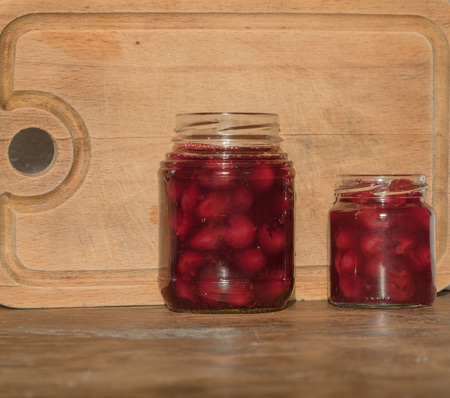 Two jars cherry jam on wooden backgroundの写真素材