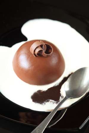 Chocolate Panna Cotta served with sweet creamy and chocolate sauces, on a black plate の写真素材