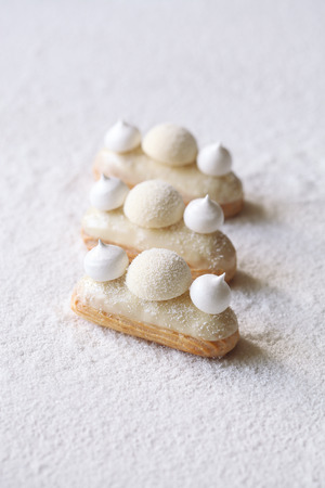 Contemporary White Chocolate and Coconut Eclairs, on white background.