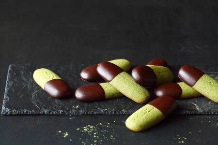 Chocolate Dipped Matcha Tea Butter Cookies, on a dark background.の写真素材