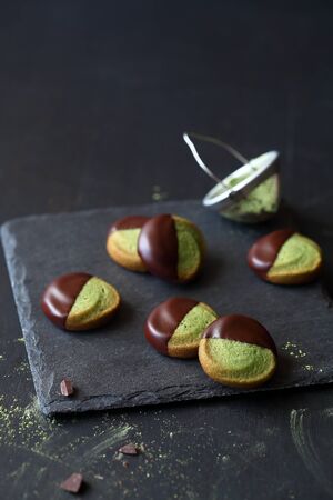Chocolate Dipped Matcha Tea Butter Cookies, on a dark background.の写真素材