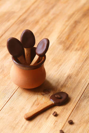 Spoon-Shaped Coffee Cookies dipped in dark chocolate, on a wooden table.の写真素材