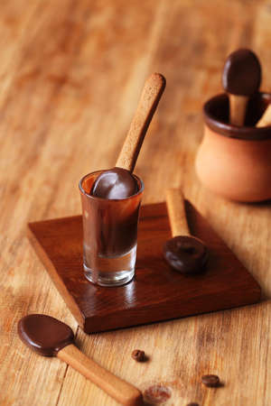 Spoon-Shaped Coffee Cookies dipped in dark chocolate, on a wooden table.の写真素材