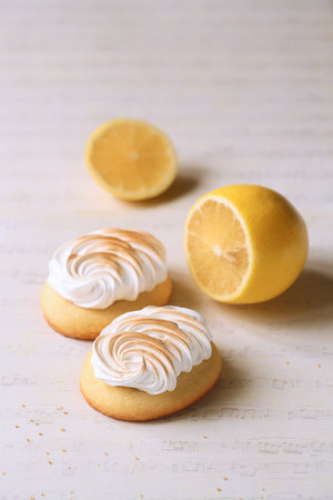 Butter Cookies with Lemon Curd and topped with Burnt Italian Meringue, on a light beige background.の写真素材