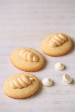 Butter Cookies with Lemon Curd and topped with Burnt Italian Meringue, on a light beige background.