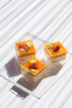 Tropical Fruit Panna Cotta, in square shot glasses, on white background.の写真素材