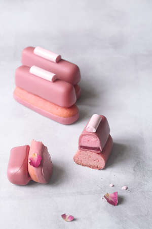 Ruby Chocolate and Raspberry Cookie Bars, garnished with meringue cookies, on gray background.の写真素材