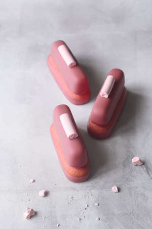 Ruby Chocolate and Raspberry Cookie Bars, garnished with meringue cookies, on gray background.の写真素材