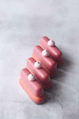 Ruby Chocolate and Raspberry Cookie Bars, garnished with meringue cookies, on gray background.の写真素材