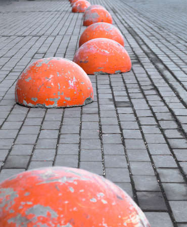 orange concrete hemispheres on road tiles. quality photoの写真素材