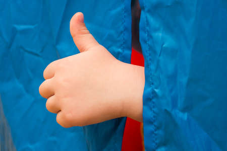 The childs hand shows the class. Peeking out from behind the curtain.