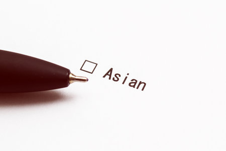Pen and the inscription Asian with a check mark on white paper. Questionnaire.の写真素材
