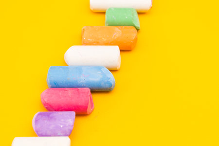Childrens drawing crayons lie in a row on a yellow background.の写真素材