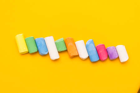 Childrens drawing crayons lie in a row on a yellow background.の写真素材