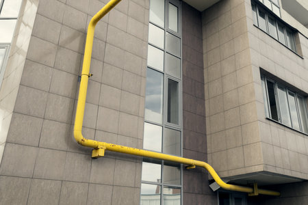 Yellow chimney on the wall of the building. Water supply to the apartment. Gas main.の写真素材
