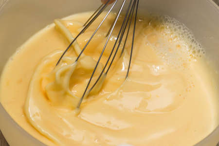 Making an omelet for breakfast. Mixing eggs and milk.の写真素材