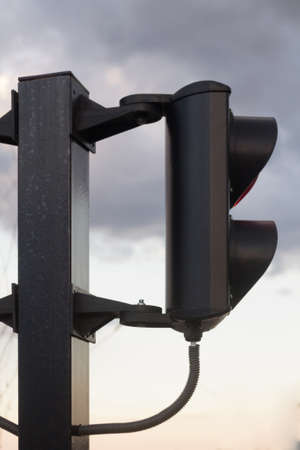 Small traffic light in the parking lot against the background of the cloudy sky.の写真素材