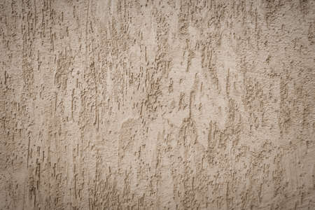Background of gray one-color facade plaster. Single-layer cement monolithic plaster for decorative background. Exterior of the building facade covered with decorative gray textured plasterの写真素材
