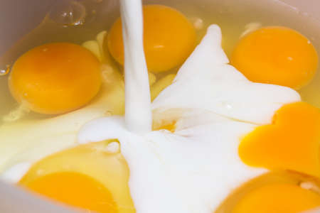 Making an omelet for breakfast. Mixing eggs and milk.の写真素材