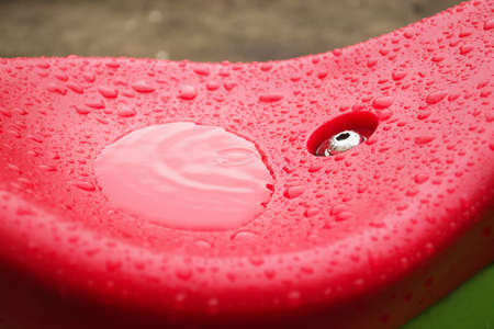 Wet swing seat close-up. Baby swing after rain.の写真素材
