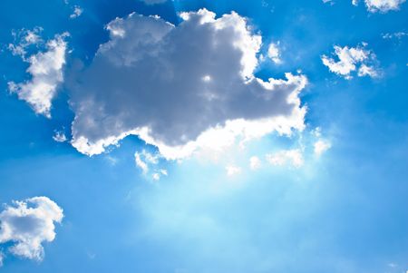 sun behind the clouds and blue skyの写真素材