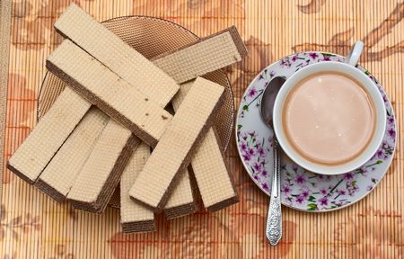 cup of coffee with milk and waffles in a bowlの写真素材
