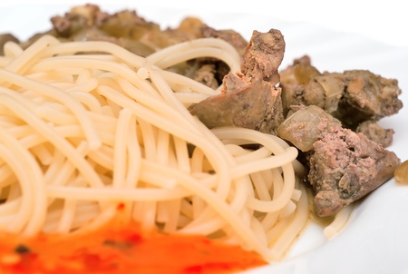 Fried liver with pasta and sauce on white plateの写真素材