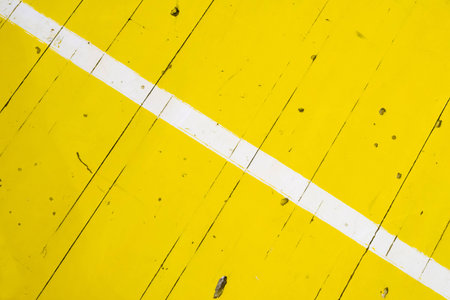 diagonal white stripe on yellow wooden floor in school sport hallの写真素材