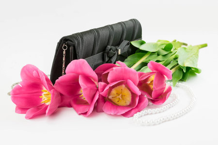 bouquet of red tulips, handbag and bead lying on a white backgroundの写真素材