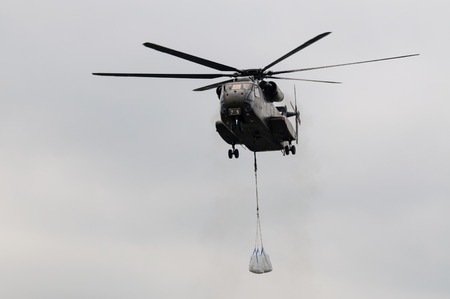 military helicopter about to transport sand bags to secure a dike against the floodのeditorial素材